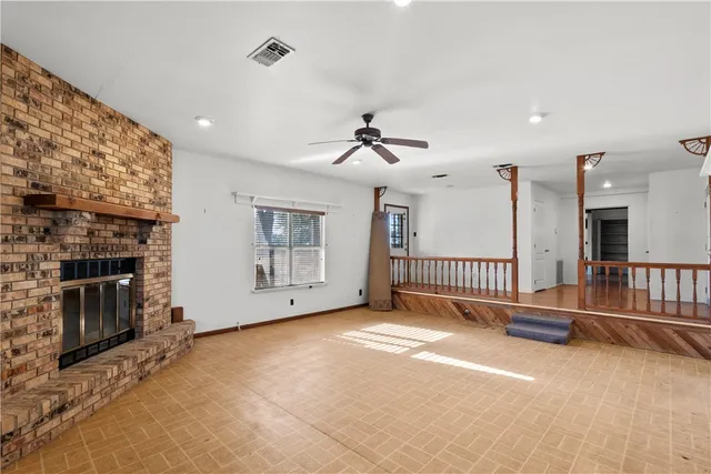 an empty room with staircase and a fireplace