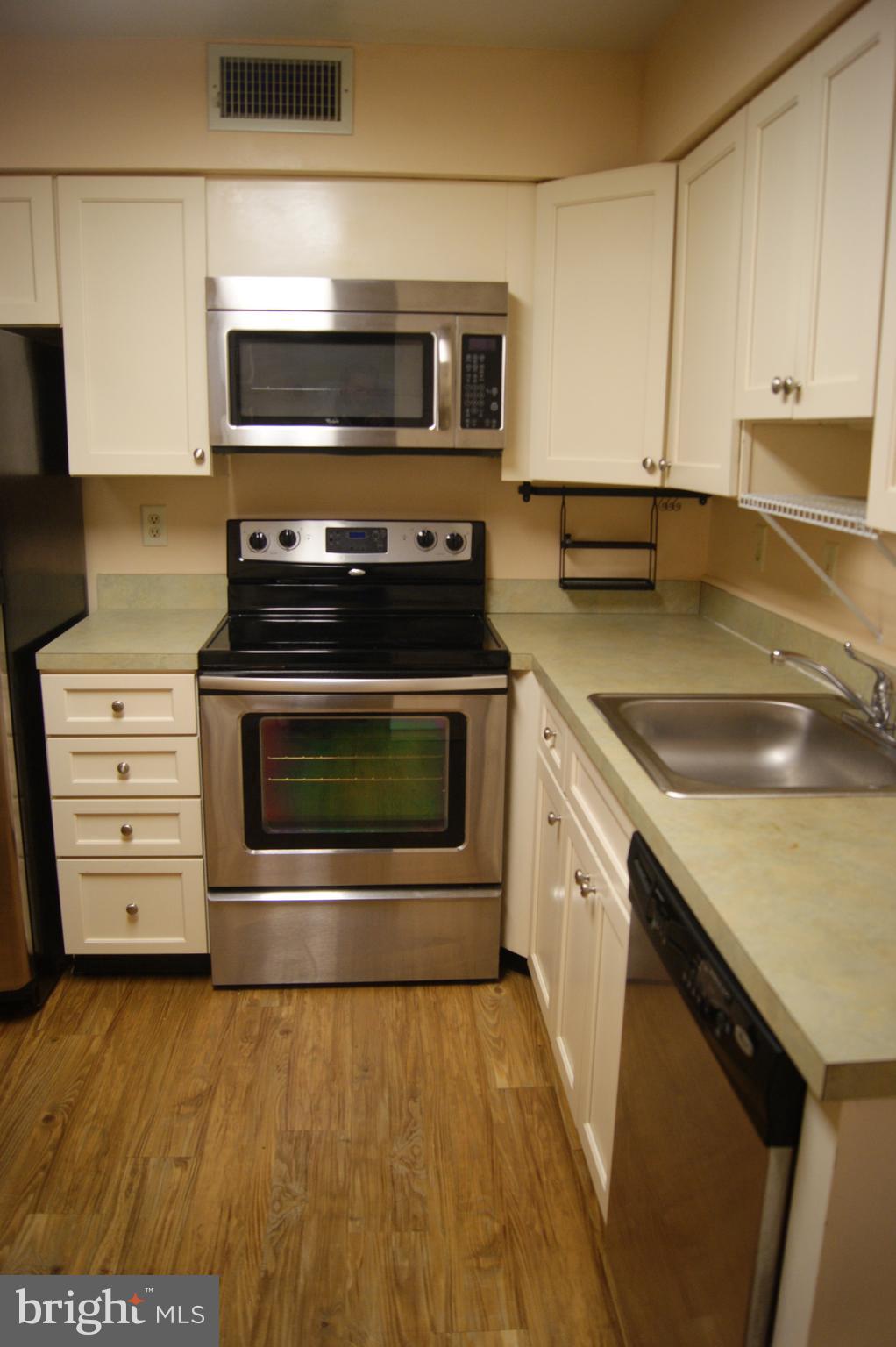 2901 Fallstaff Road, Unit 205 Baltimore, MD 21209 - Photo 11 of 24 a kitchen with stainless steel appliances granite countertop a stove microwave and sink