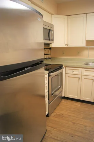 a kitchen with an oven a cabinets and wooden floor