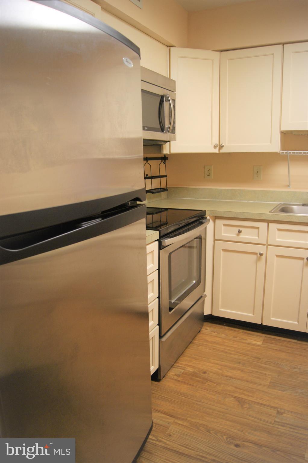 2901 Fallstaff Road, Unit 205 Baltimore, MD 21209 - Photo 9 of 24 a kitchen with granite countertop a stove and a microwave