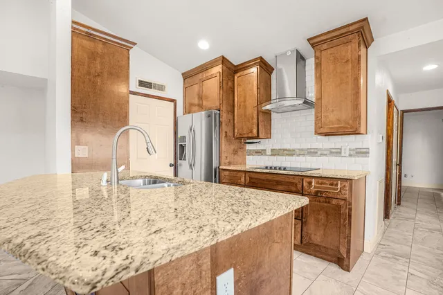 a kitchen with a granite countertop sink and refrigerator