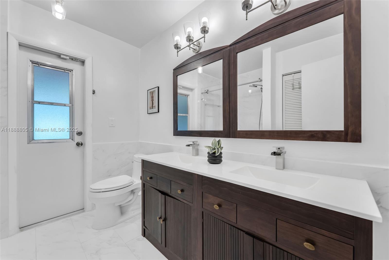 11614 Southwest 101st Terrace Miami, FL 33176 - Photo 9 of 17 a bathroom with a toilet sink double and mirror