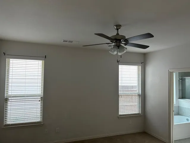a view of a livingroom with a ceiling fan and window