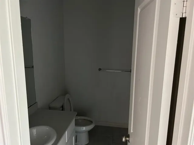 a white toilet sitting next to a shower