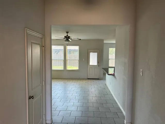 a view of a hallway with windows and chandelier