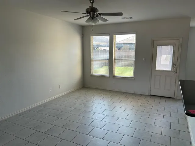 an empty room with windows and fan