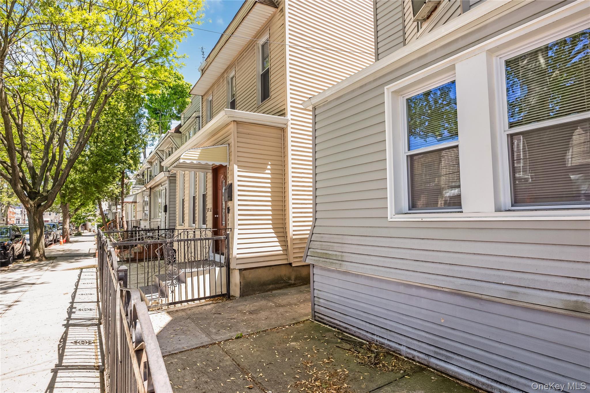 80-50 88th Road Queens, NY 11421 - Photo 20 of 21 a view of a house with a small deck and a large tree