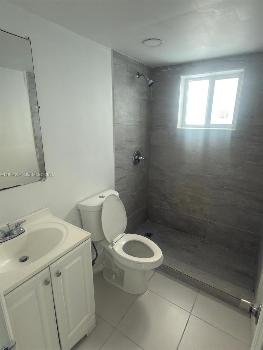2622 Northwest 24th Street, Unit 1B Miami, FL 33142 - Photo 13 of 16 a bathroom with a toilet sink and shower