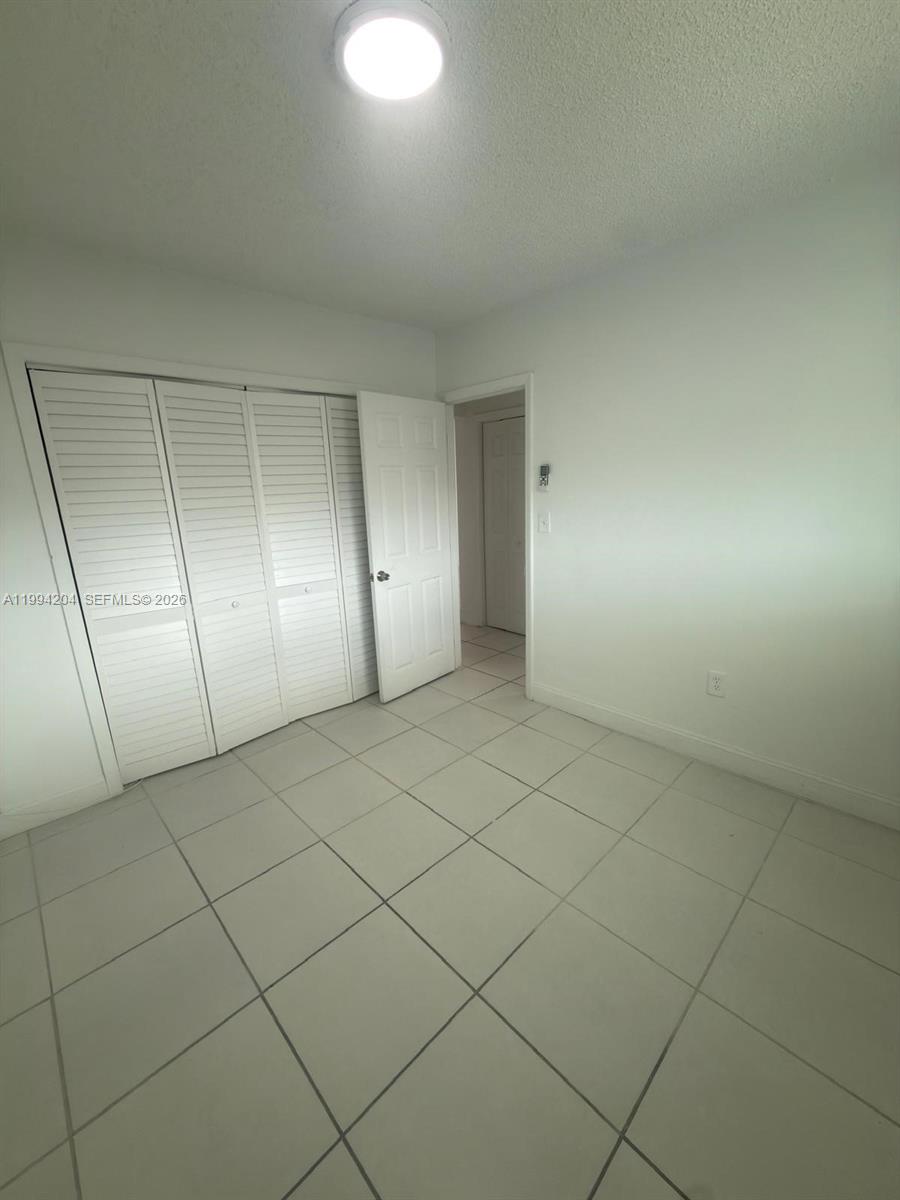 2622 Northwest 24th Street, Unit 1B Miami, FL 33142 - Photo 15 of 16 an empty room with a bench and cabinet