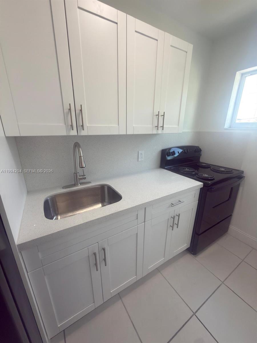 2622 Northwest 24th Street, Unit 1B Miami, FL 33142 - Photo 5 of 16 a kitchen with a sink and cabinets