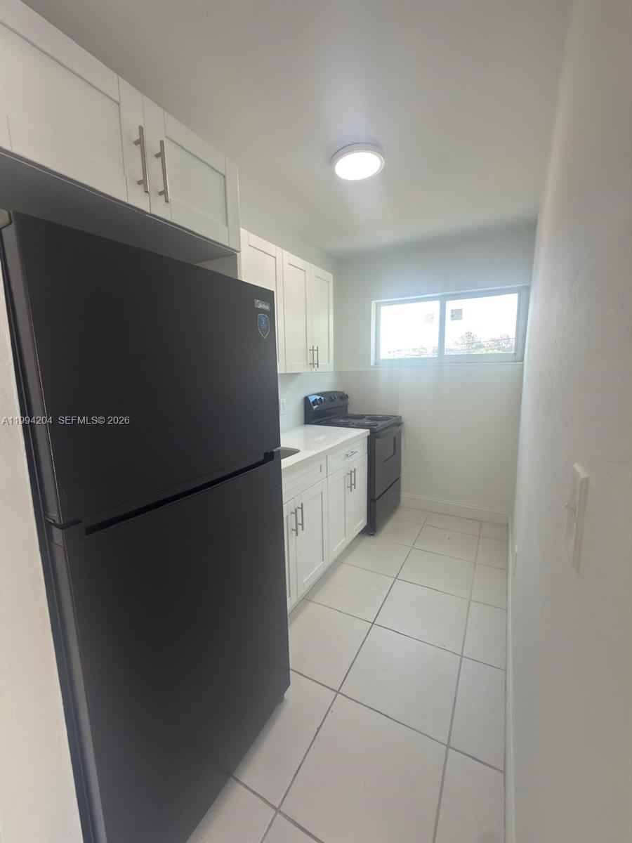 2622 Northwest 24th Street, Unit 1B Miami, FL 33142 - Photo 6 of 16 a white refrigerator freezer sitting inside of a kitchen