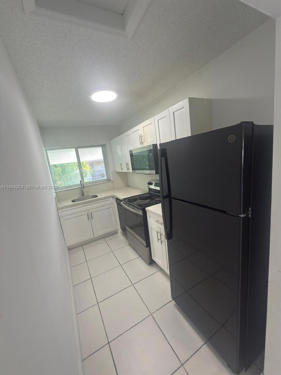 2622 Northwest 24th Street, Unit 1B Miami, FL 33142 - Photo 8 of 16 a kitchen with stainless steel appliances a refrigerator and a sink