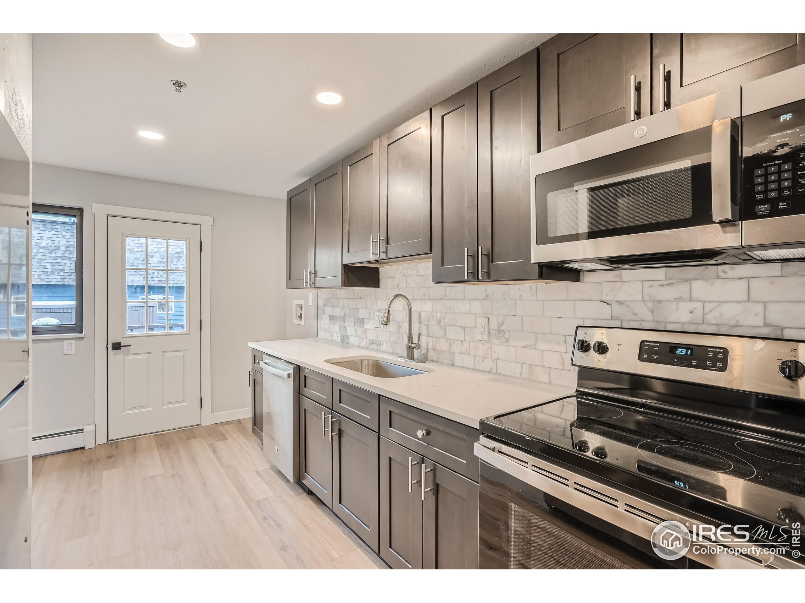 a kitchen with stainless steel appliances kitchen island granite countertop a sink stove and microwave