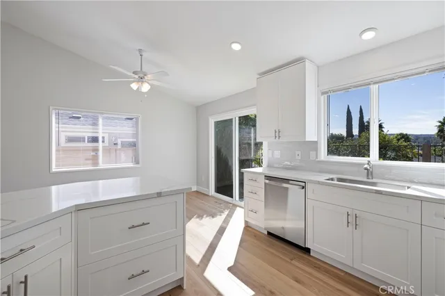 a kitchen with a sink window and cabinets