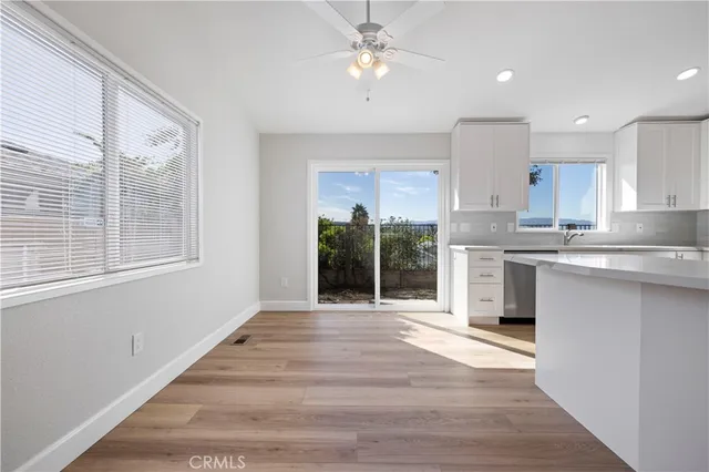 a kitchen with stainless steel appliances granite countertop a stove a sink and a refrigerator with wooden floors