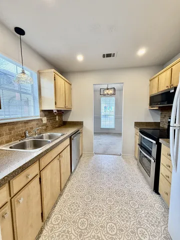a kitchen with stainless steel appliances granite countertop a stove a sink and a refrigerator