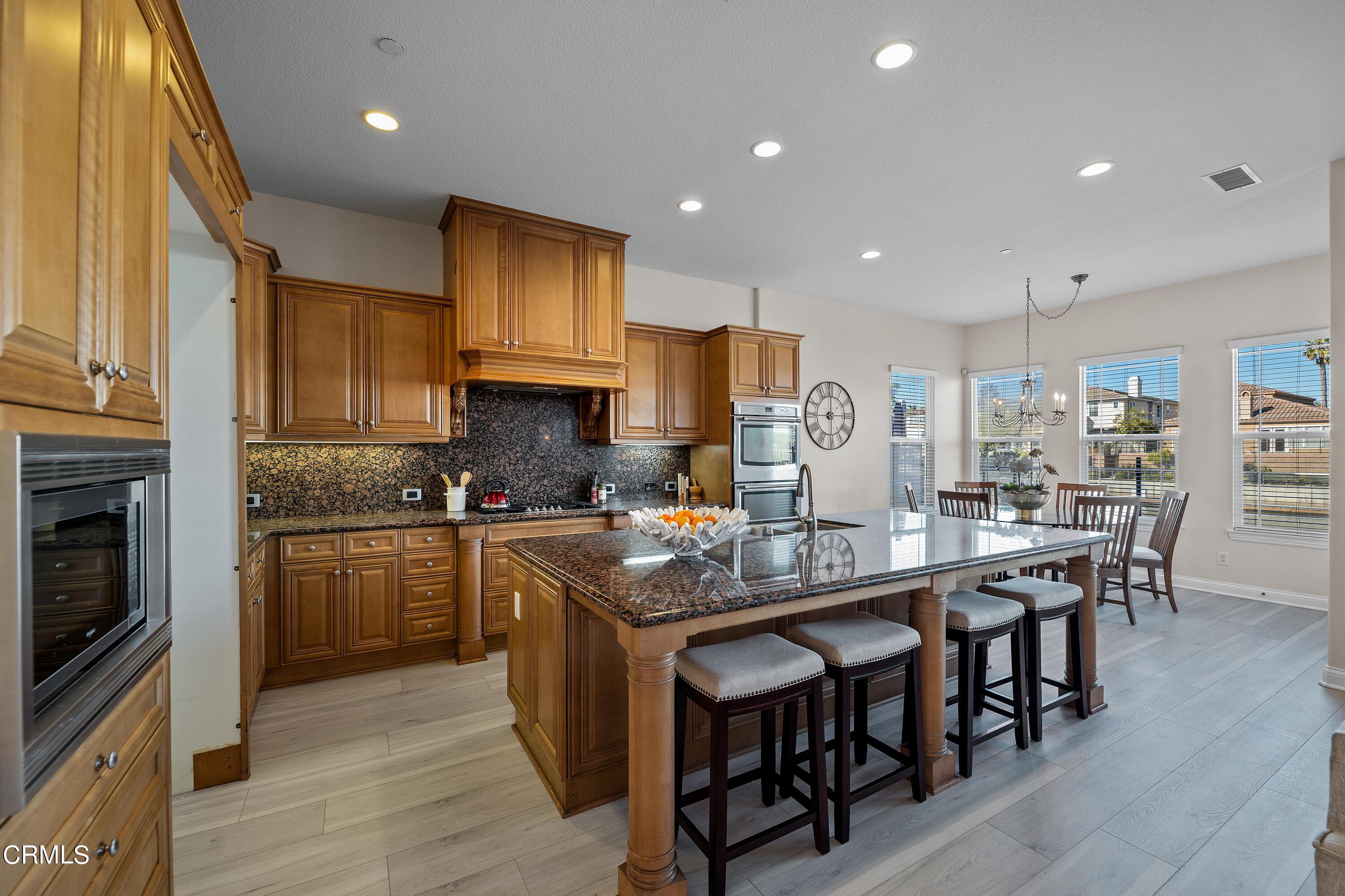 3957 West Hemlock Street Oxnard, CA 93035 - Photo 20 of 46 a kitchen with stainless steel appliances granite countertop wooden cabinets a stove top oven a sink and dishwasher