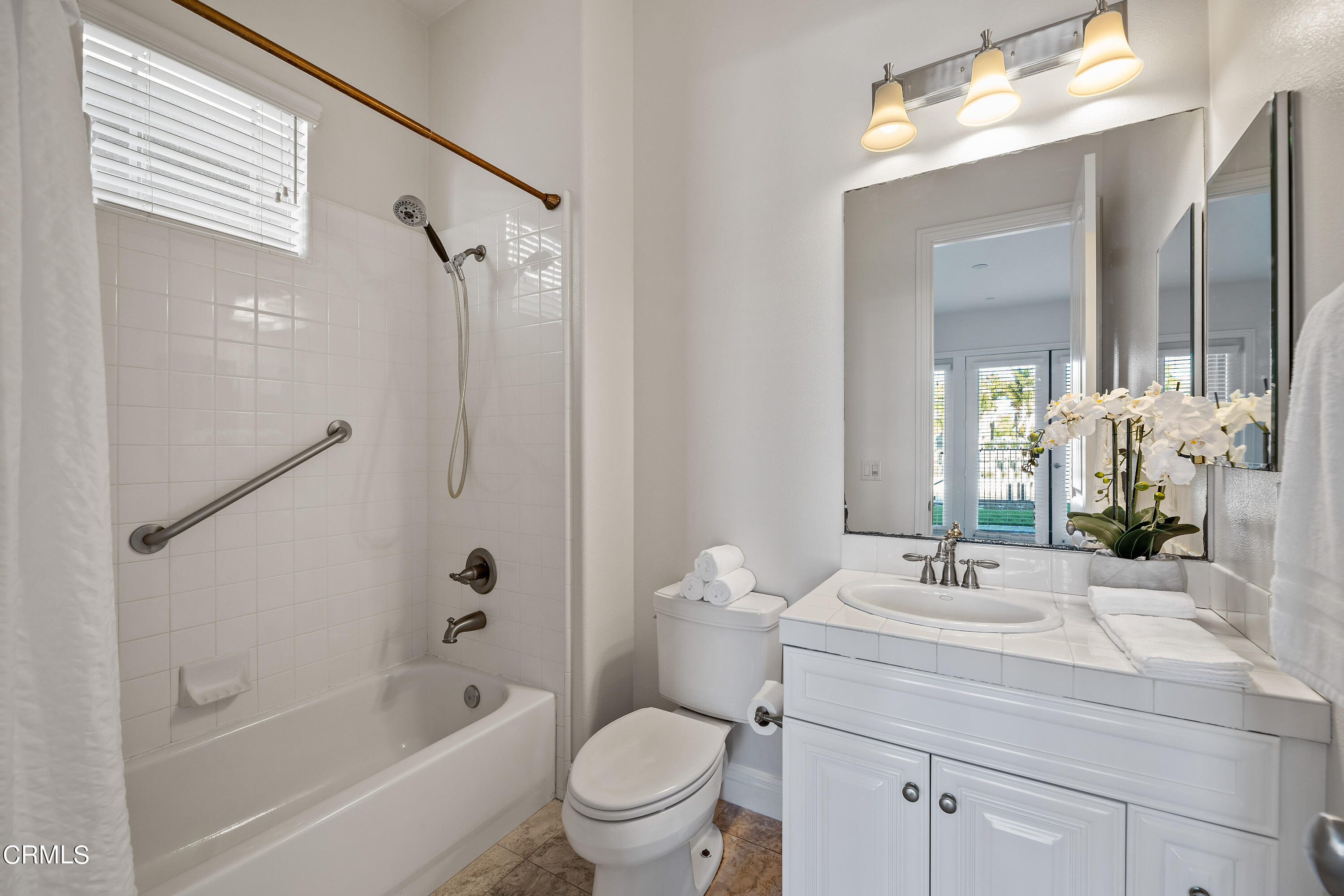 3957 West Hemlock Street Oxnard, CA 93035 - Photo 29 of 46 a bathroom with a sink a toilet a mirror a bathtub and shower