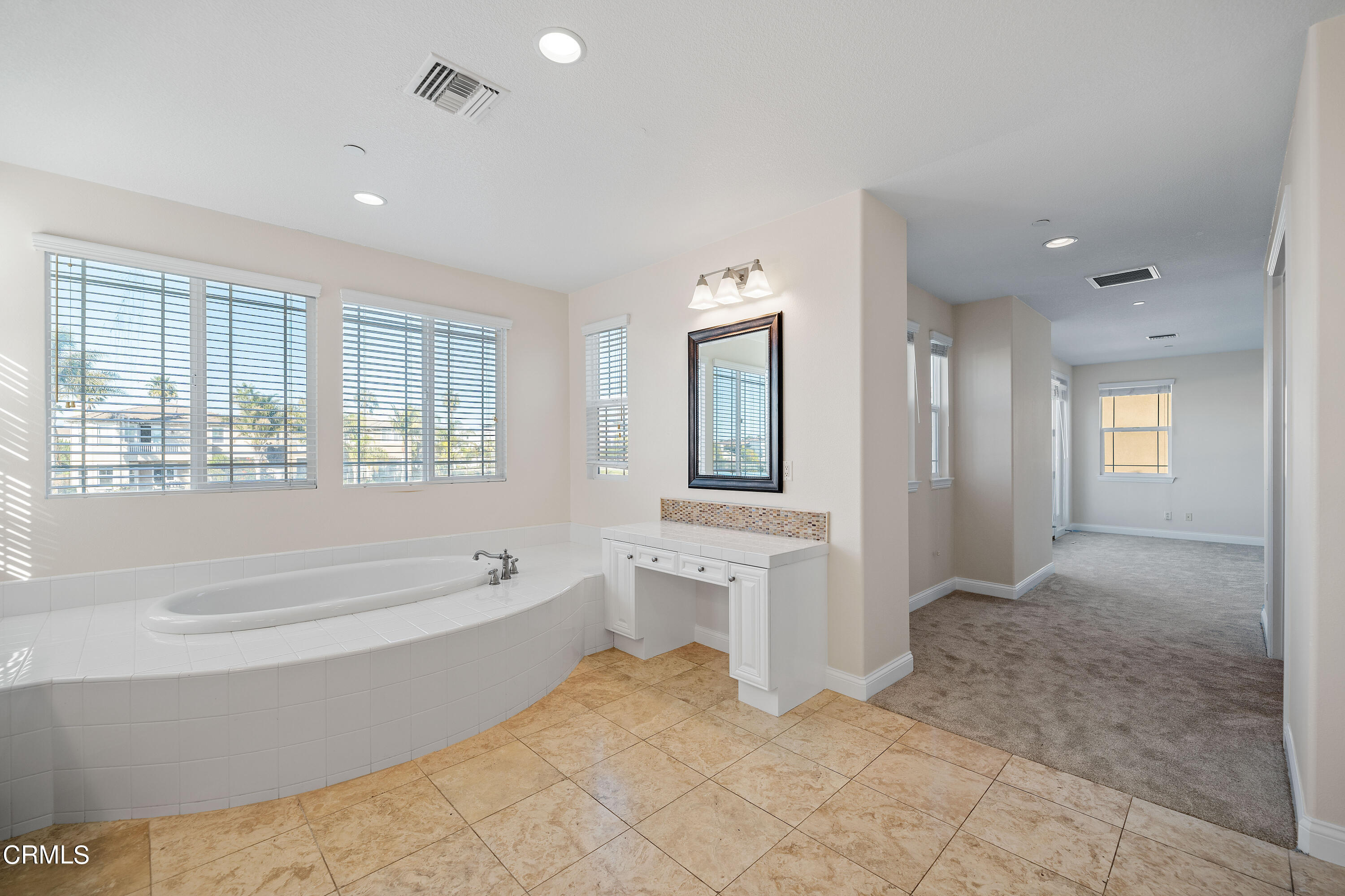3957 West Hemlock Street Oxnard, CA 93035 - Photo 42 of 46 a spacious bathroom with a tub sink and mirror