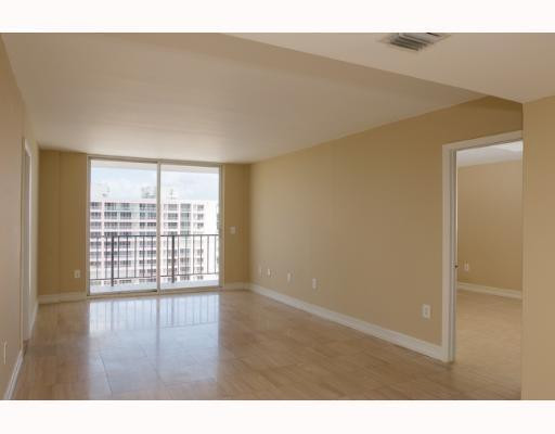 9273 Collins Avenue, Unit 1109 Surfside, FL 33154 - Photo 4 of 8 a view of an empty room with wooden floor and a window