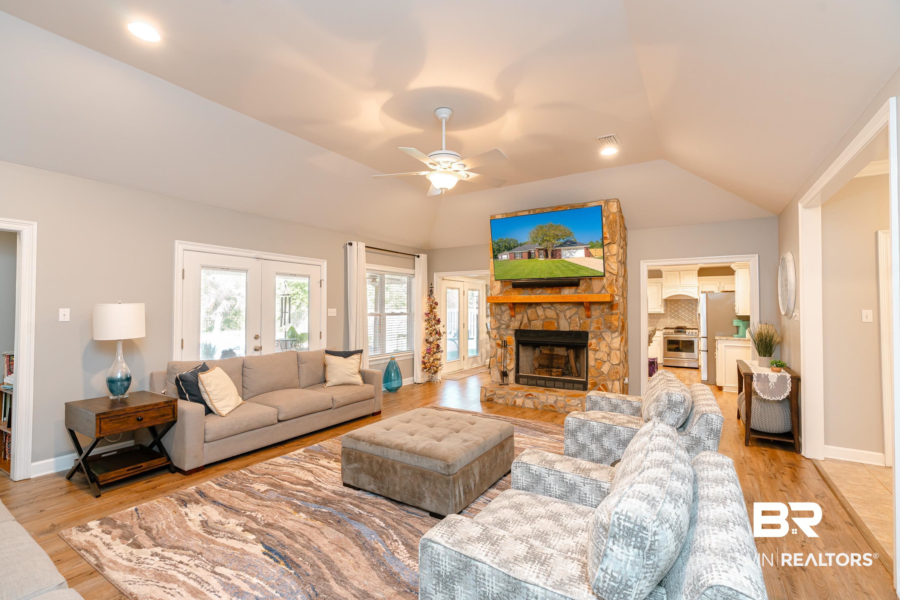 9477 Deerfield Drive Irvington, AL 36544 - Photo 5 of 58 Living room featuring ceiling fan, a stone fireplace, light wood-type flooring, and lofted ceiling
