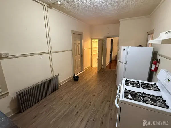 an empty room with wooden floor and front door