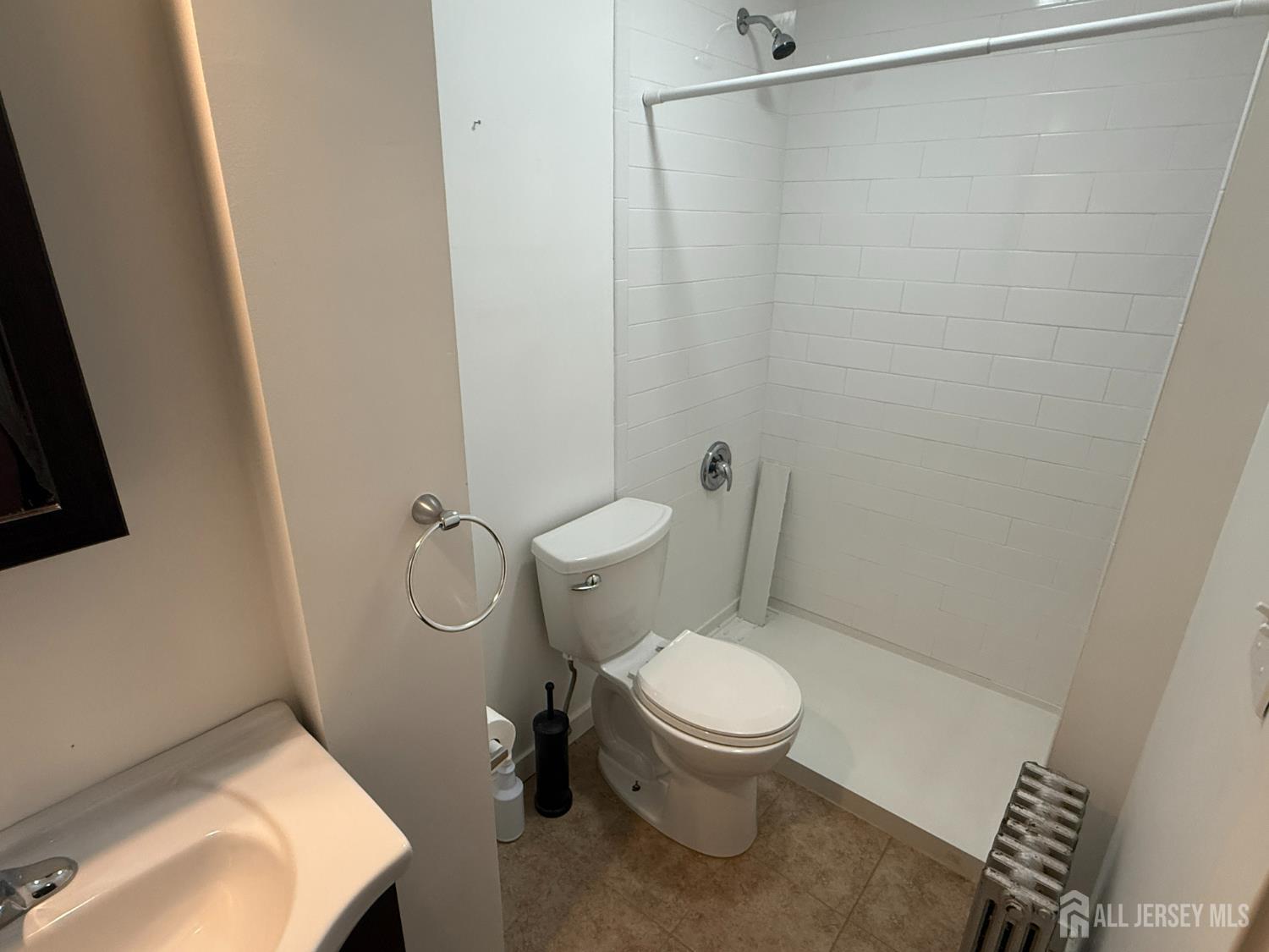 69 West Somerset Street, Unit D Raritan, NJ 08869 - Photo 10 of 12 a white toilet sitting next to a bathroom sink