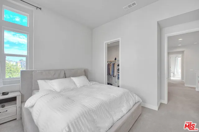 a large bed in a bedroom next to a window