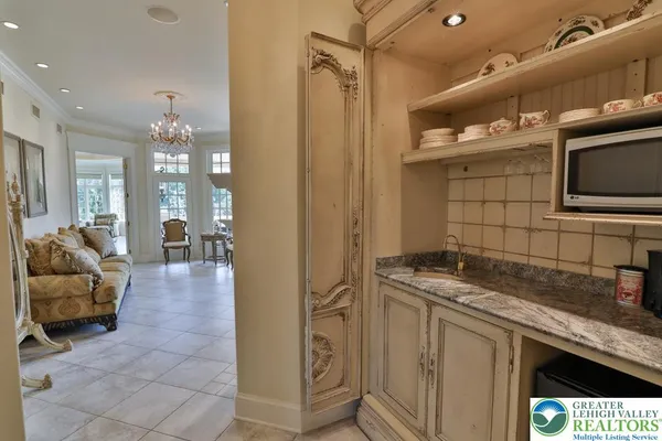 a bathroom with a granite countertop sink a large mirror and a bathtub next to a window