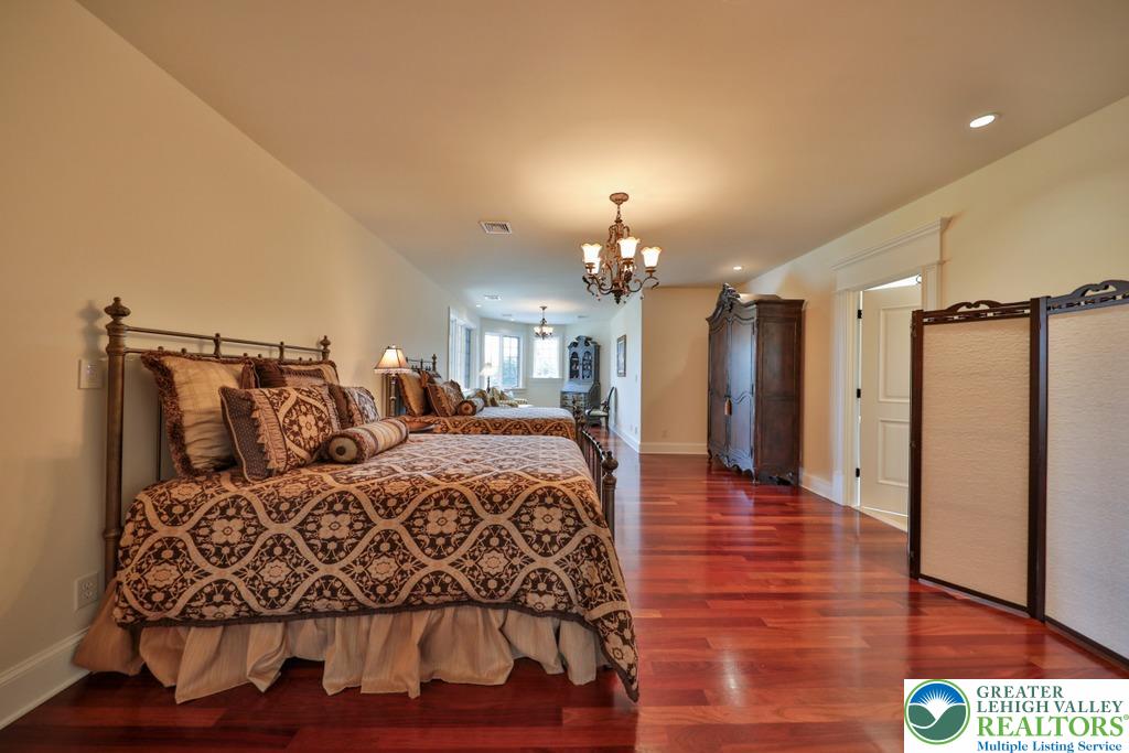 5044 Vera Cruz Road Center Valley, PA 18034 - Photo 47 of 100 a spacious bedroom with a bed and a chandelier
