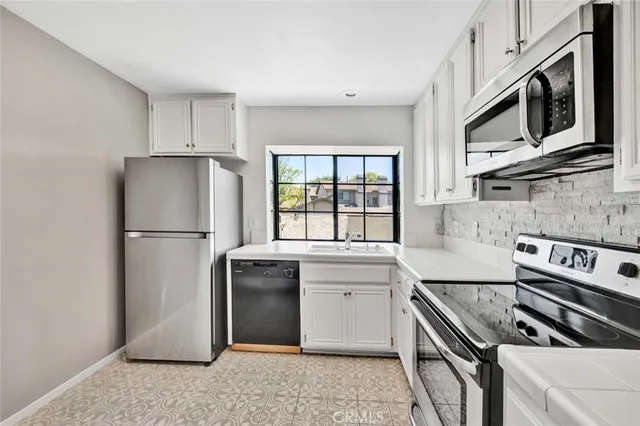 a kitchen with stainless steel appliances granite countertop a refrigerator stove top oven and sink
