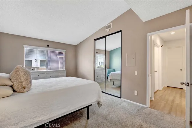 a bedroom with a bed and painting on the wall