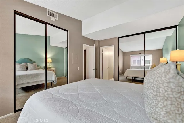 a bedroom with a large bed and a mirror