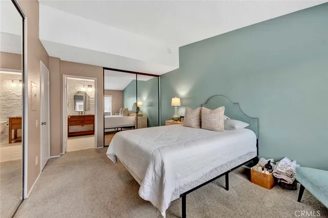 a spacious bedroom with a bed and large mirror