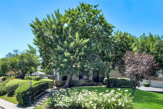 a backyard of a house with lots of green space and fountain