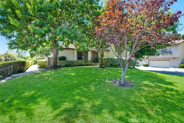 a front view of house with a garden and trees