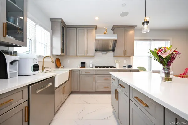 a large kitchen with stainless steel appliances kitchen island granite countertop a lot of counter space and a sink