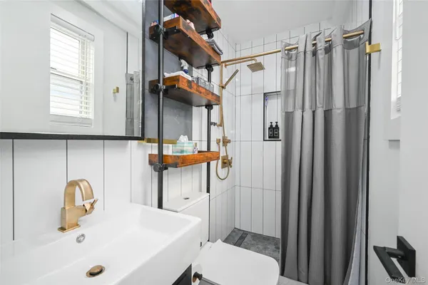 a bathroom with a sink a toilet and shower