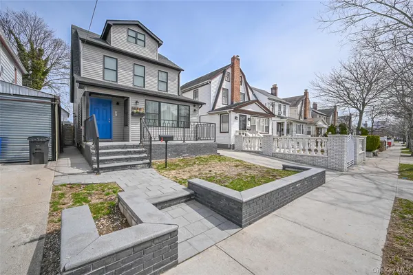 a view of house with entryway and wooden stairs