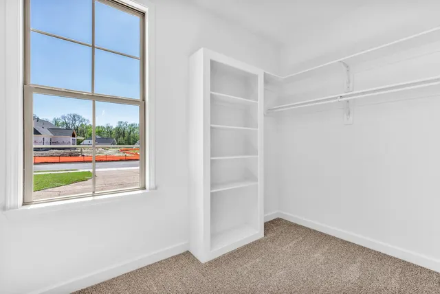 an empty room with windows and chandelier fan