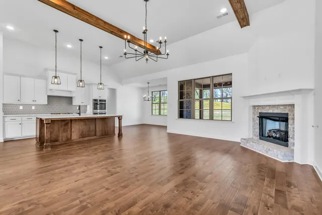 a view of a kitchen and an empty room with chandelier