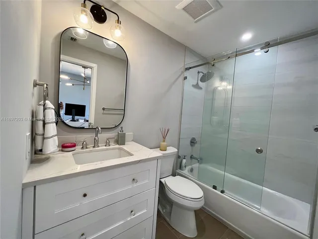 a bathroom with a toilet a sink a tub and mirror