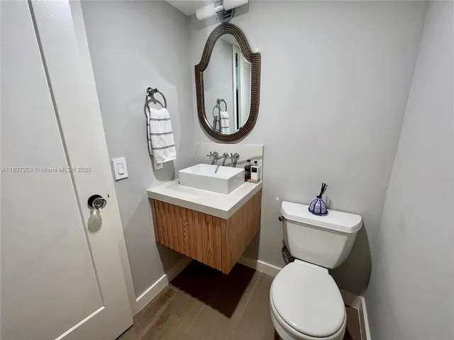 a bathroom with a toilet sink vanity and mirror