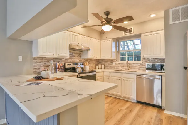 a view of a hallway with wooden floor and stairs