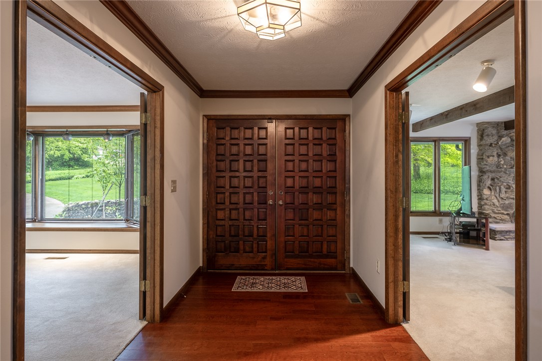 273 North Alpha Bellbrook Road Dayton, OH 45434 - Photo 3 of 43 Enter through elegant wooden doors into a home framed by expansive views of lush greenery.