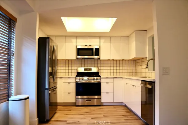 a kitchen with a refrigerator and a stove top oven