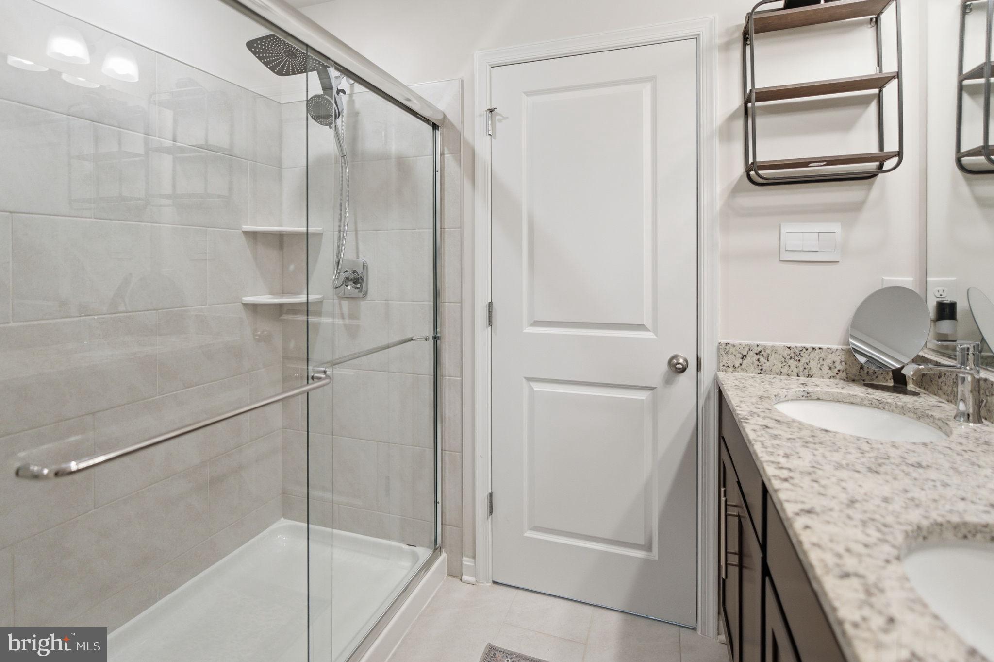 715 Courier Lane Frederick, MD 21701 - Photo 15 of 26 a bathroom with a granite countertop sink a mirror and shower