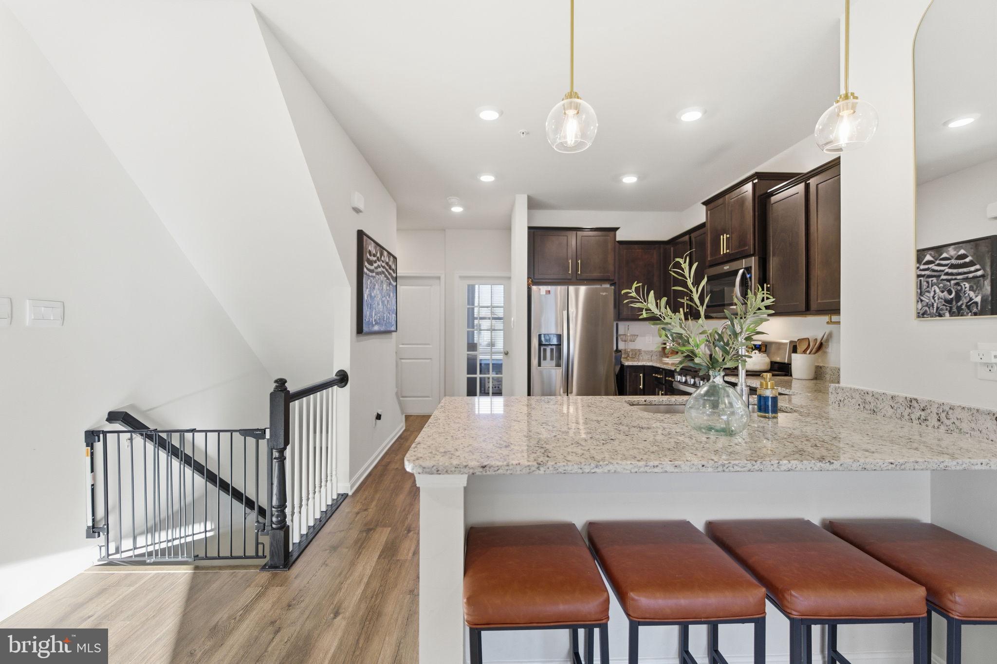 715 Courier Lane Frederick, MD 21701 - Photo 19 of 26 a kitchen with stainless steel appliances granite countertop table chairs sink and cabinets
