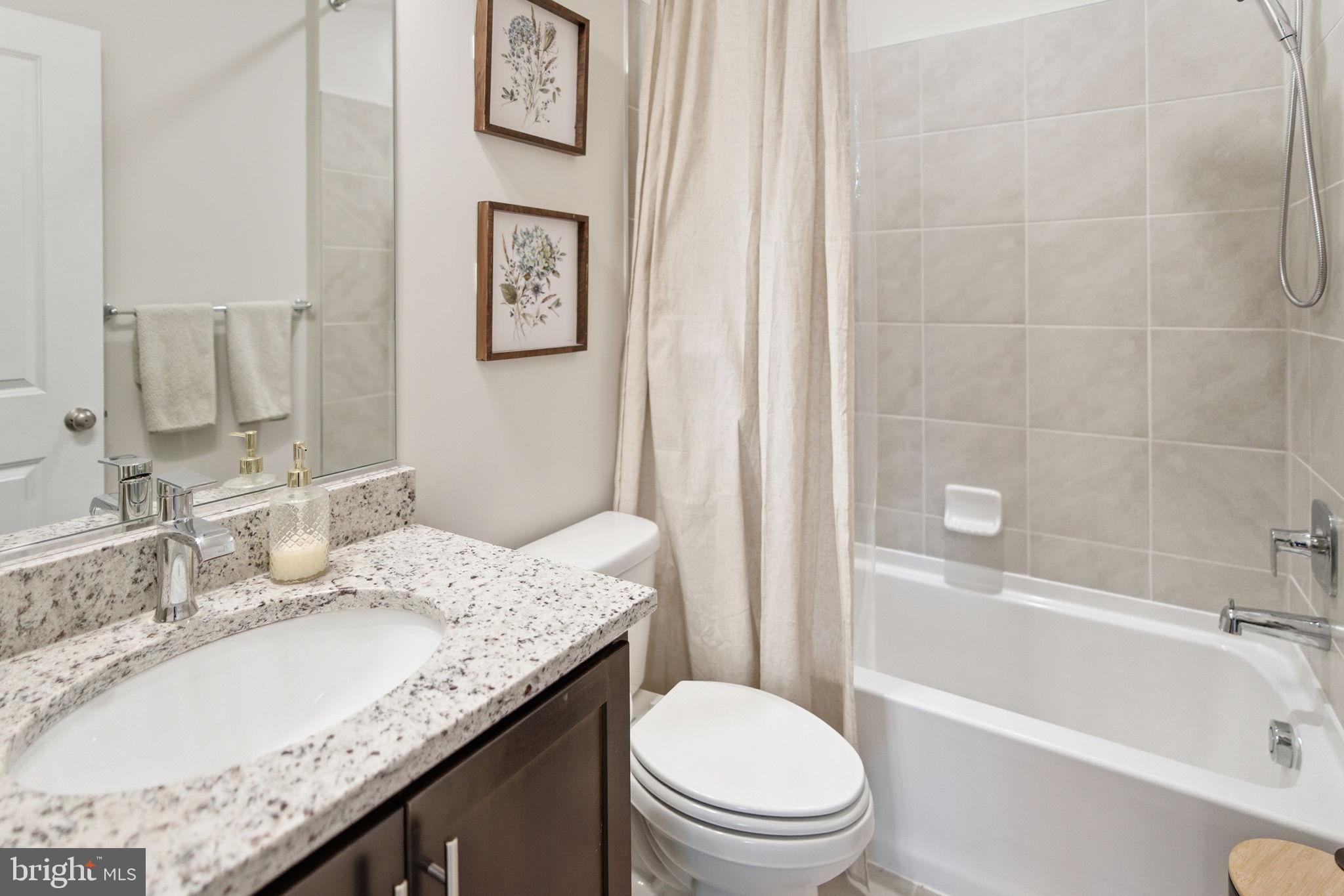 715 Courier Lane Frederick, MD 21701 - Photo 22 of 26 a bathroom with a granite countertop toilet sink and bathtub