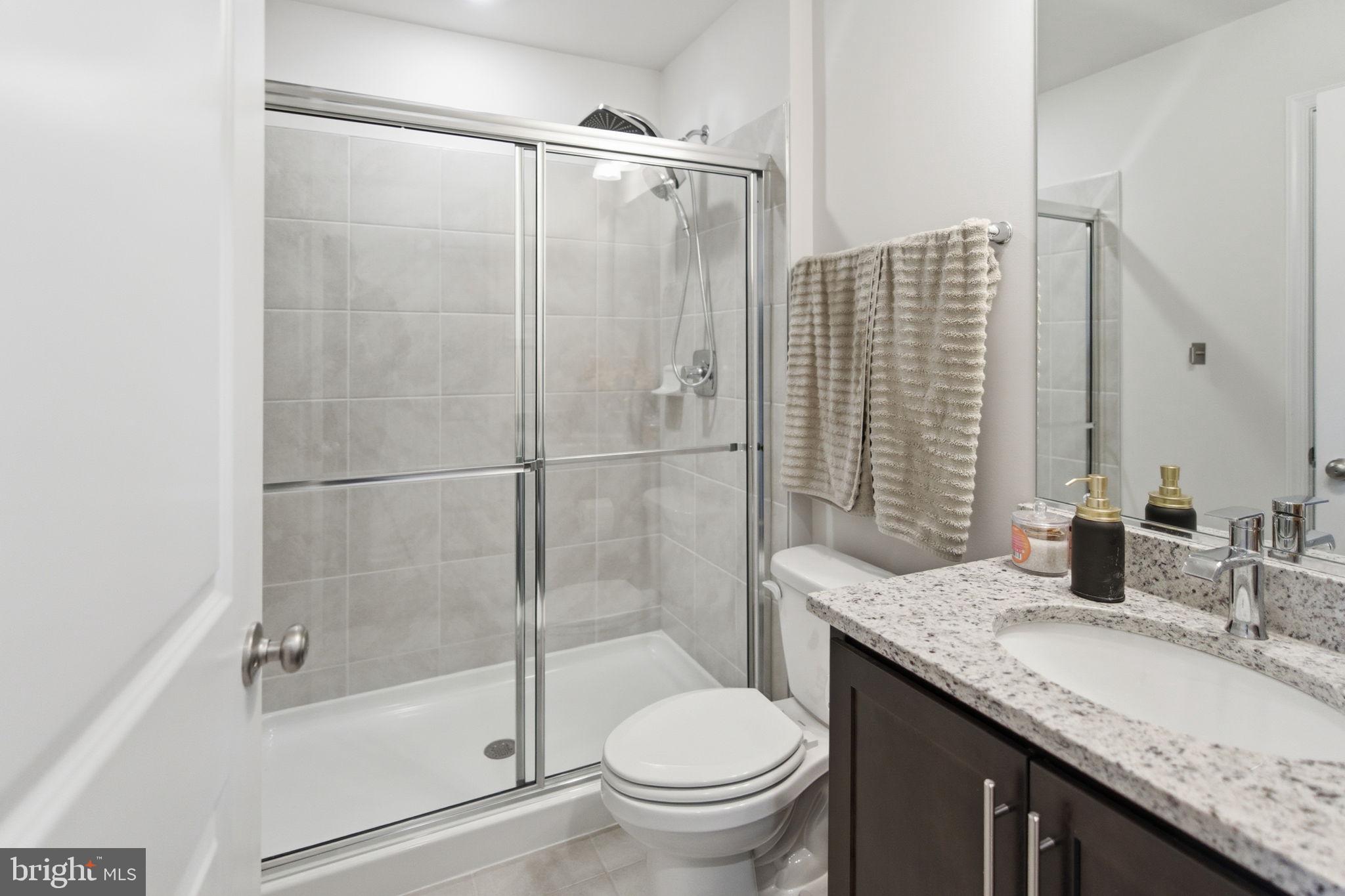 715 Courier Lane Frederick, MD 21701 - Photo 25 of 26 a bathroom with a granite countertop sink toilet and shower